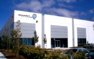 A large, bright white building with an "Alexander's Mobility" sign.