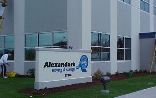 A gray and white "Alexander's Mobility Moving & Storage" sign outside.